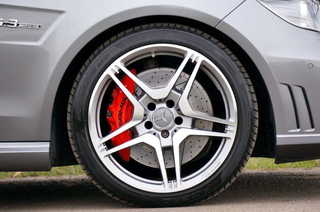 High-performance Mercedes-Benz wheel with red brake caliper, emphasizing tire maintenance and vehicl.