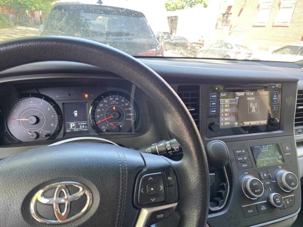 Toyota vehicle dashboard with steering wheel and infotainment system.