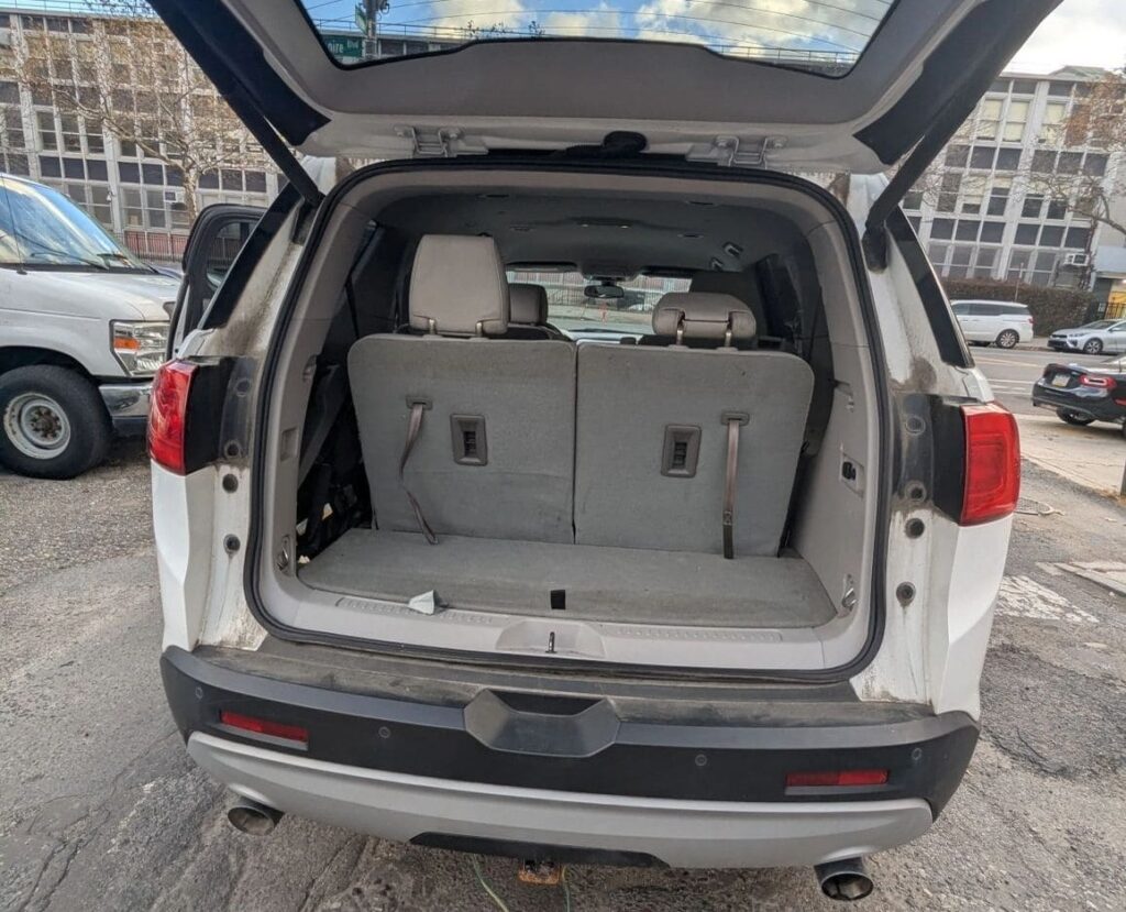 Spacious cargo area in a white SUV with open trunk, ideal for transporting luggage and goods.
