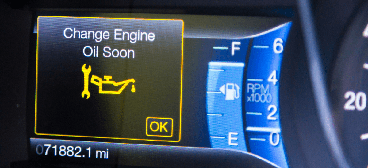 Car dashboard warning for engine oil change needed.