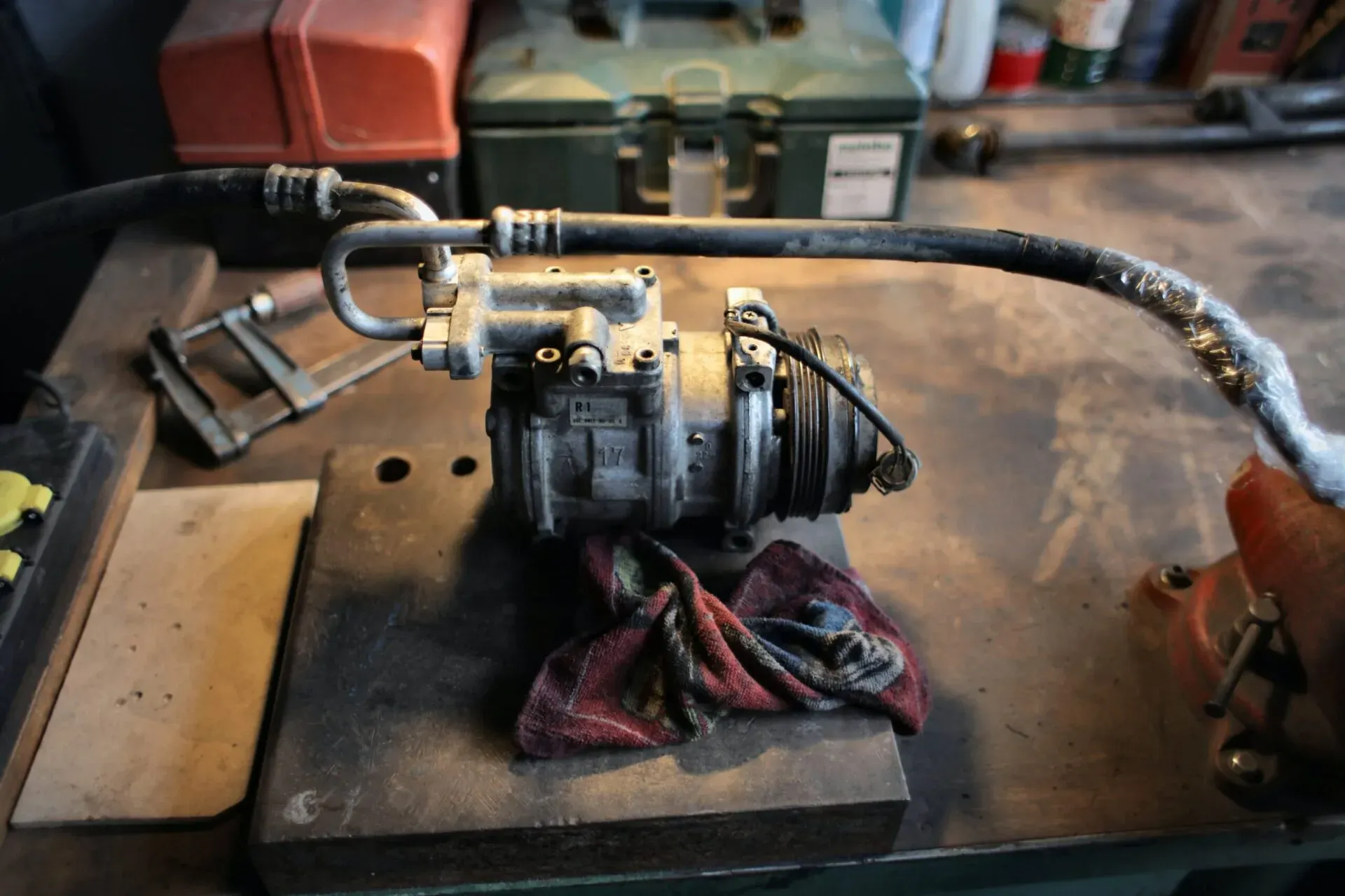 Auto AC compressor showing signs of wear and needing replacement.