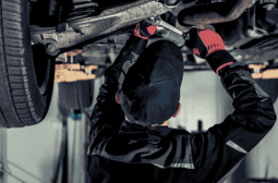 Transmission repair technician inspecting a vehicle's transmission system.