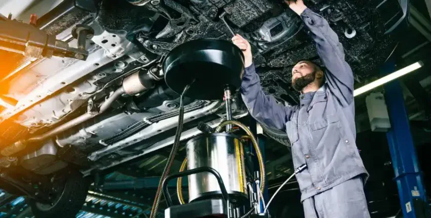 Skilled technician inspecting vehicle transmission system during repair service.