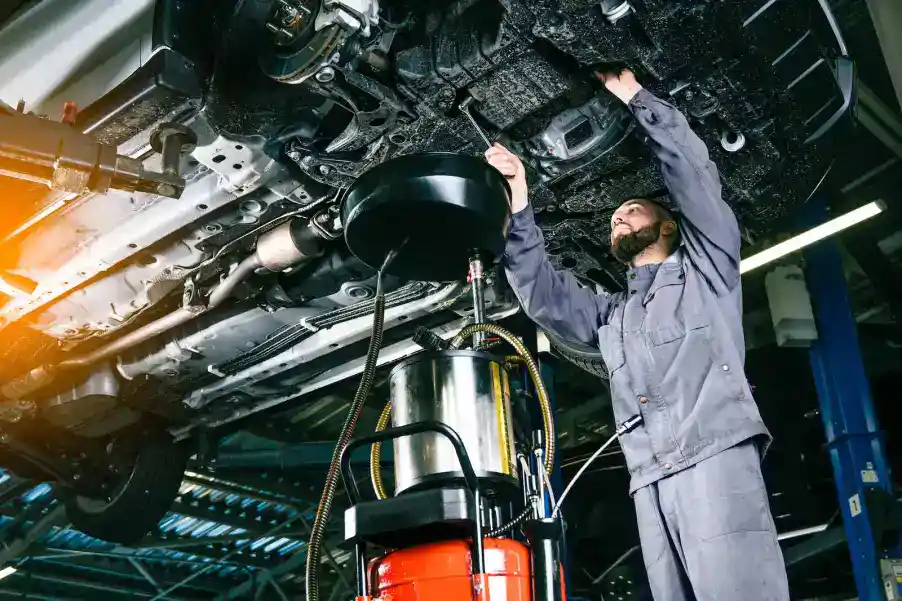 Skilled technician inspecting vehicle transmission system during repair service.