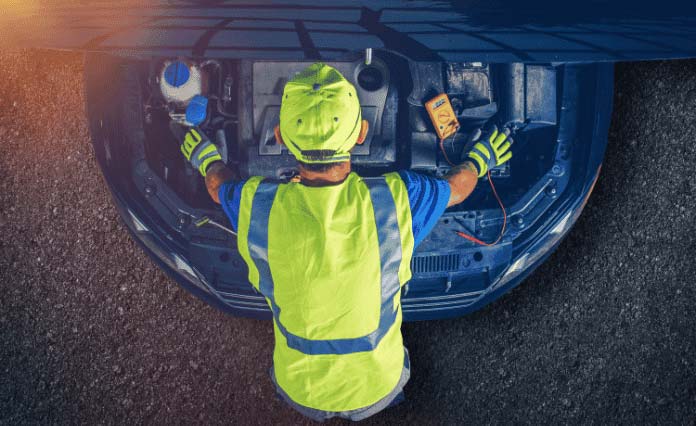 Transmission repair technician inspecting car transmission with diagnostic tools.