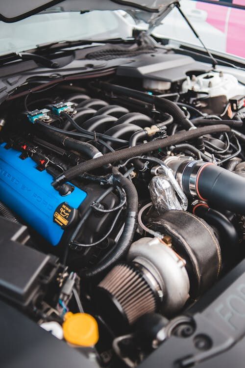 Close-up of a car engine bay highlighting transmission components and engine details.