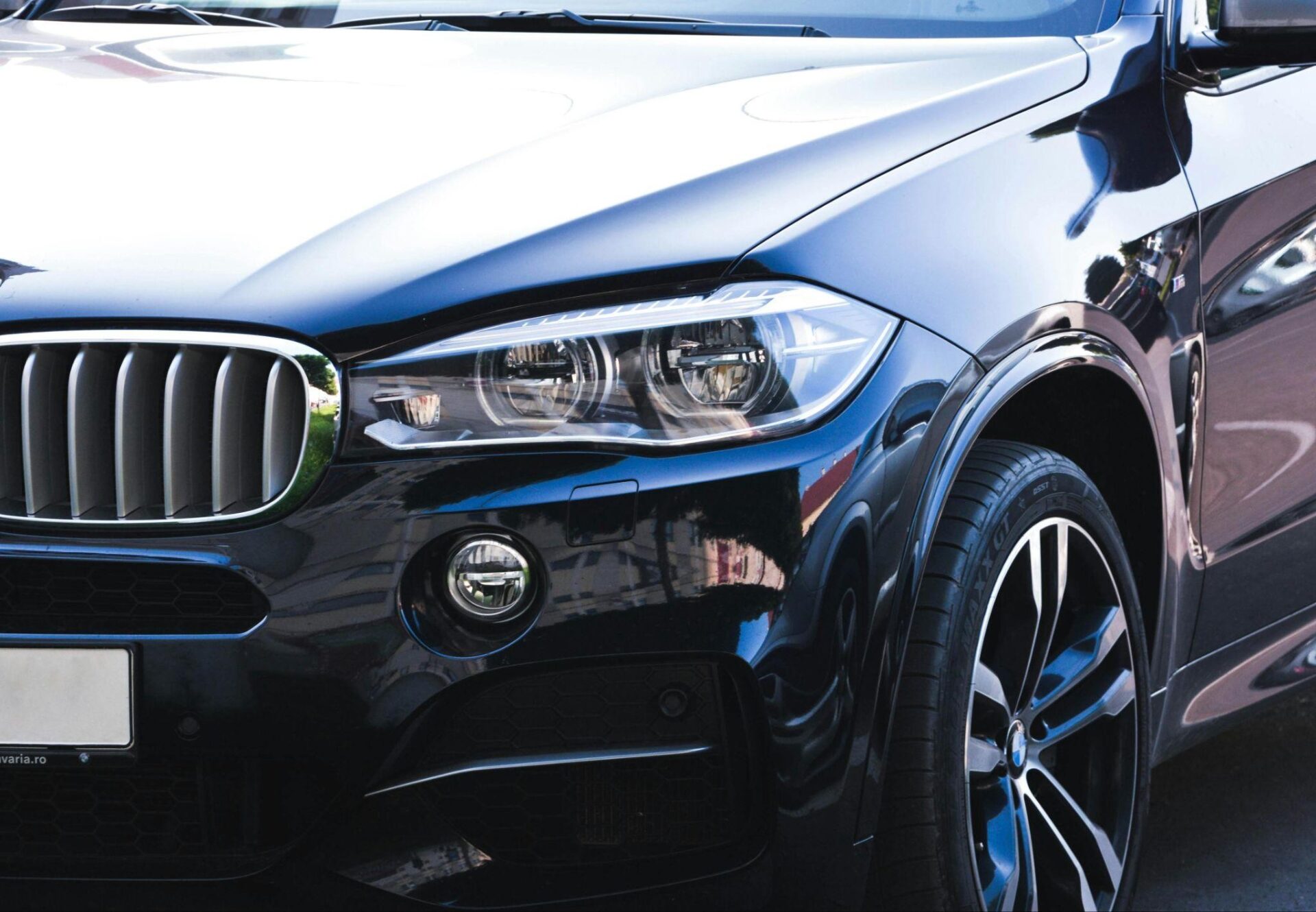 A close up shot of s BMW's front headlight and grill
