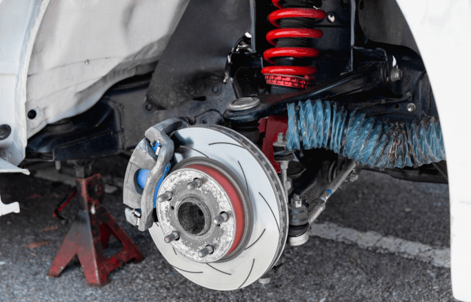 Vehicle wheel and brake system being serviced at auto repair shop.