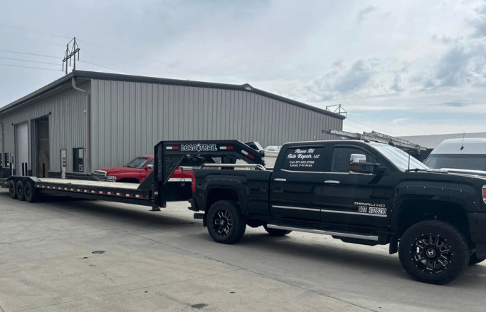 Auto repair service truck with flatbed trailer at Above All Auto Repair.
