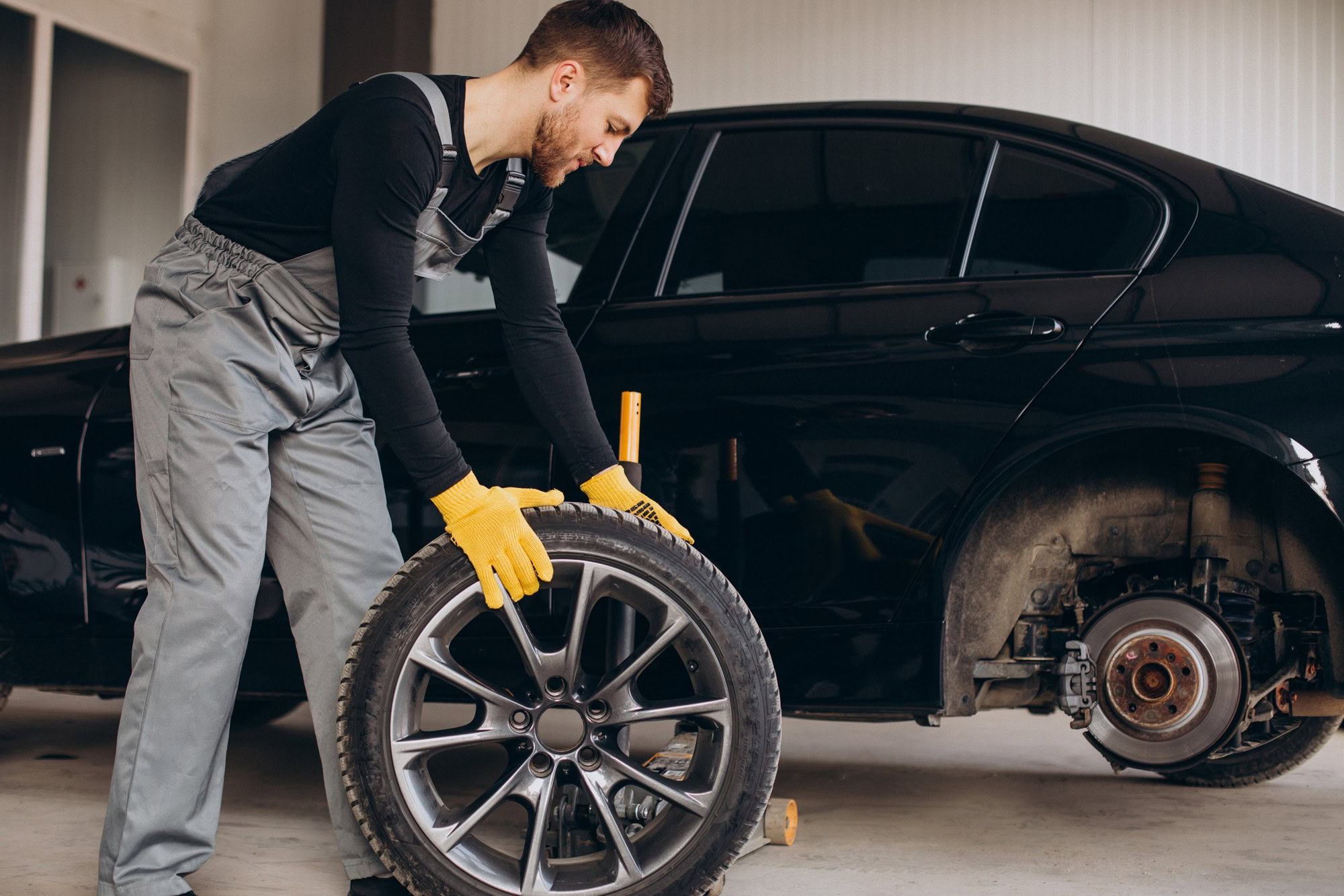 Mechanic rolling the tire away for repairs