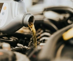 Oil being poured into a car engine during maintenance at Aliso Viejo Auto Service.