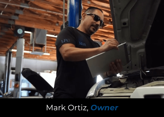 Mark Ortiz inspecting a vehicle engine at Al’s Automotive repair shop.