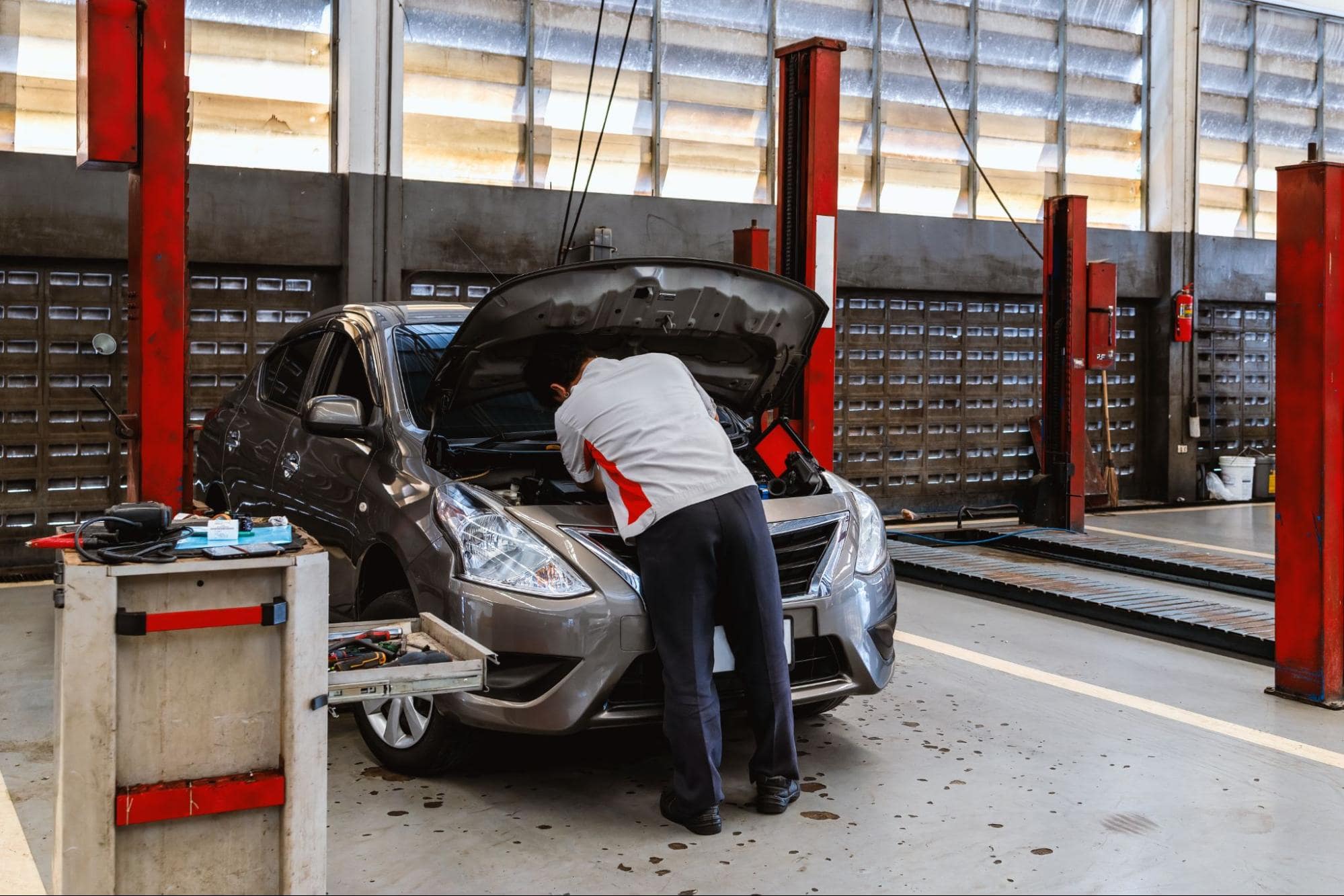 Auto repair technician inspecting a car engine at Al’s Automotive.