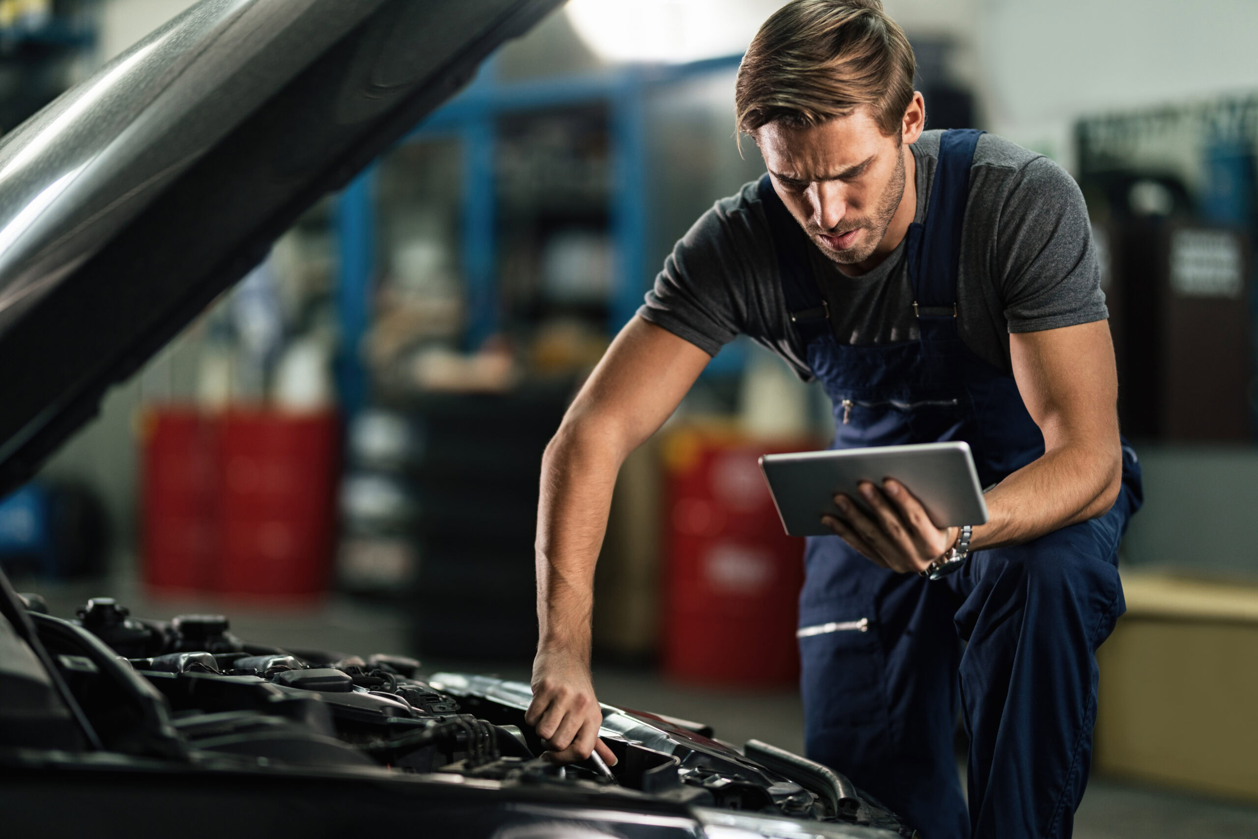 Optima car repair technician using a tablet for diagnostics.