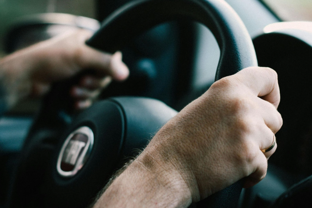 Driver holding steering wheel showing vibration at highway speeds.
