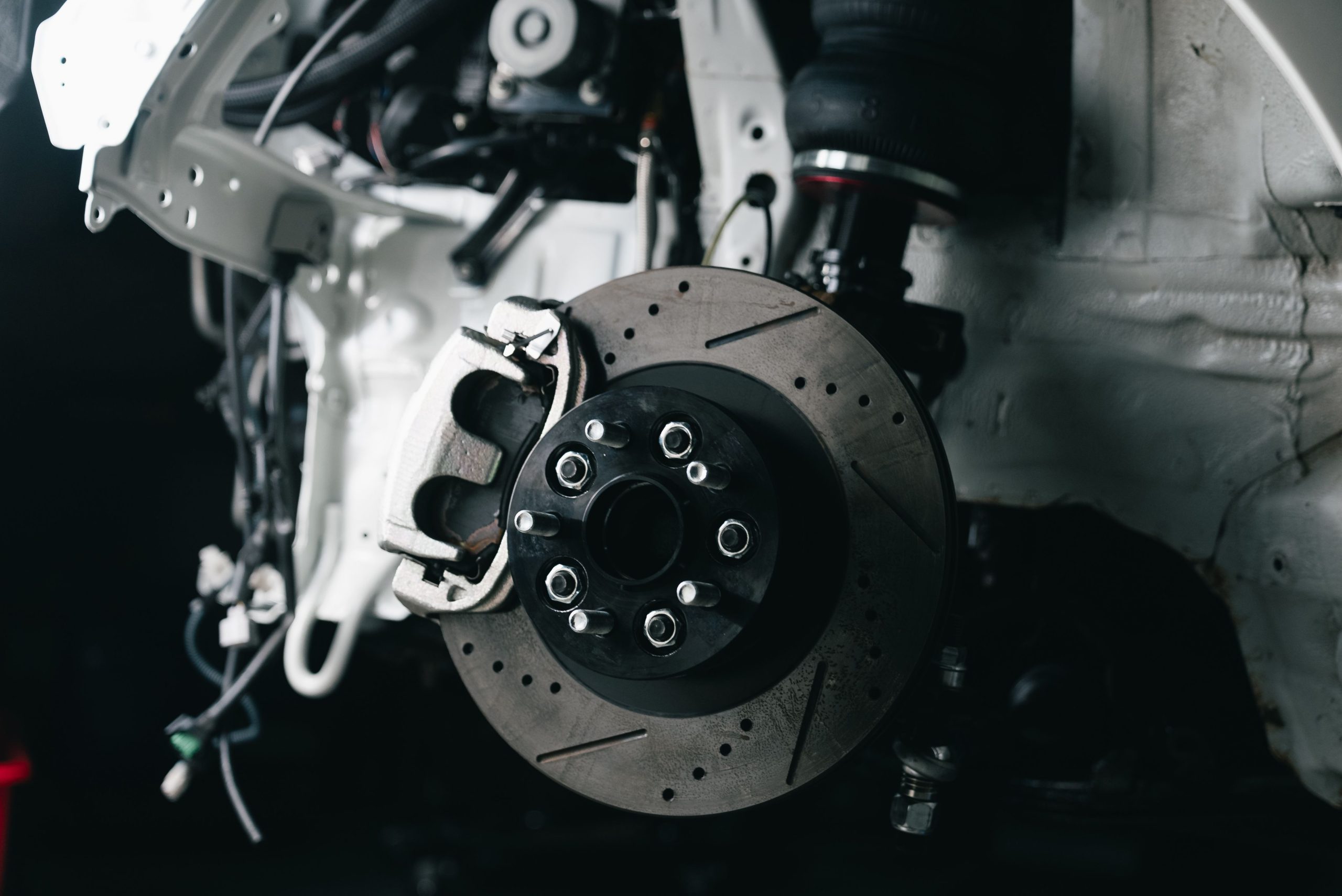 Close-up of a car's brake disc and suspension components.