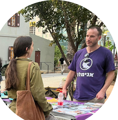 פעיל של אנימלס בדוכן הסברה ברחוב מדבר עם חיילת