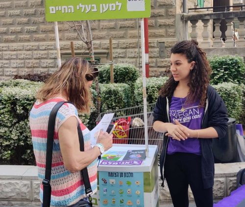 פעילה מסבירה על זכויות בעלי חיים בדוכן הסברה של אנימלס