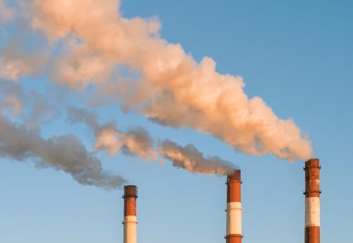 ארובות פולטות עשן על רקע שמיים כחולים