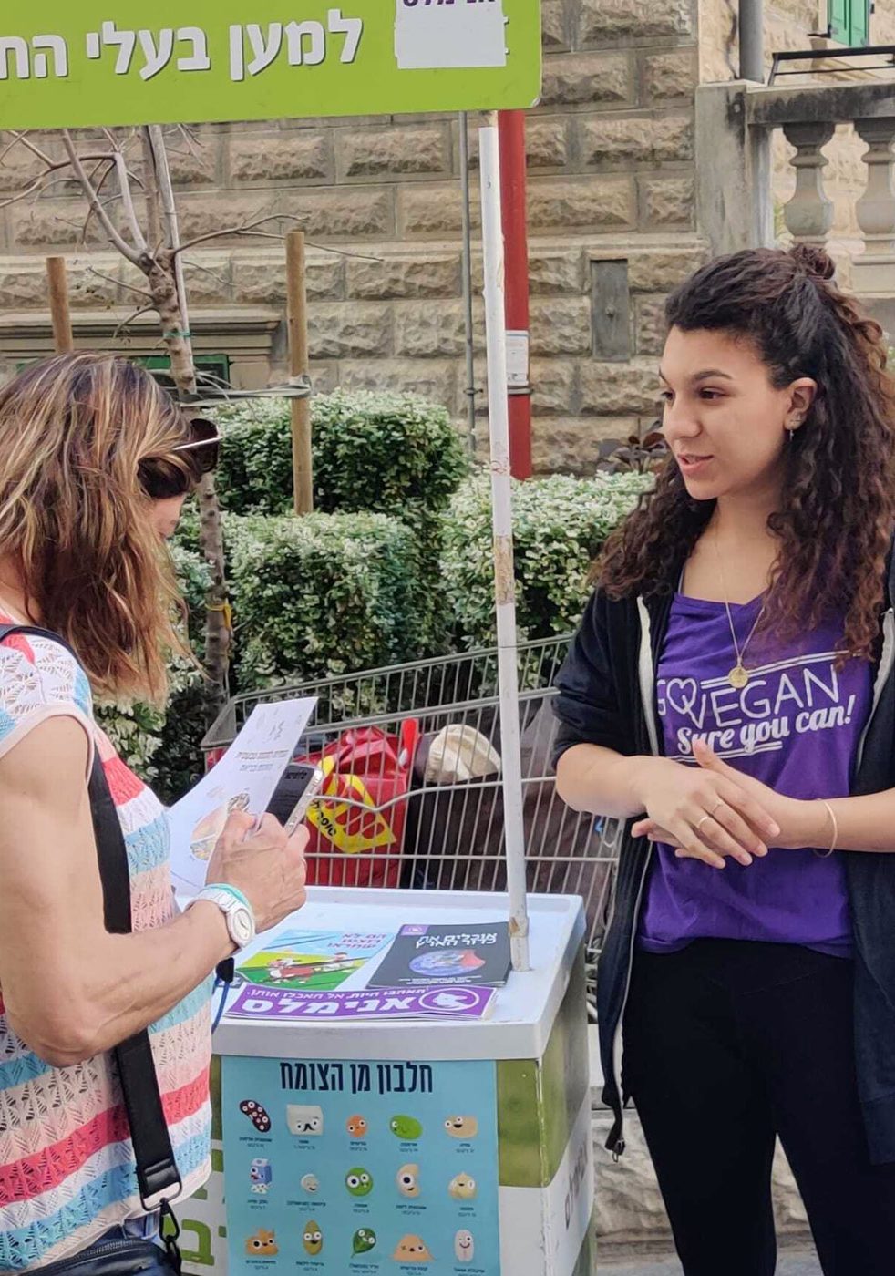 פעילה מסבירה על זכויות בעלי חיים בדוכן הסברה של אנימלס