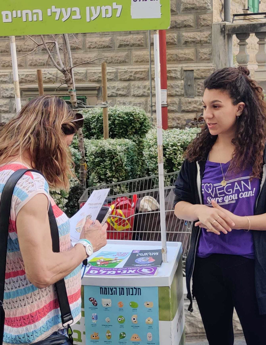 פעילה מסבירה על זכויות בעלי חיים בדוכן הסברה של אנימלס