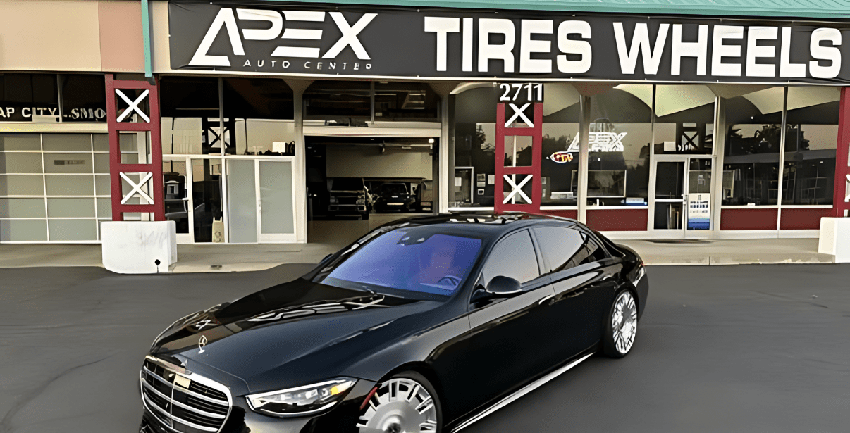 Apex Auto Center tire and wheel shop with a sleek black car parked outside, offering expert auto rep.