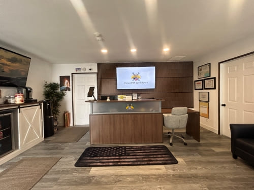Modern office reception with desk, TV, and seating area at Army Mechanics Inc.
