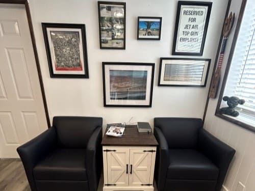 Office waiting area with framed military-themed photos and a reserved sign.