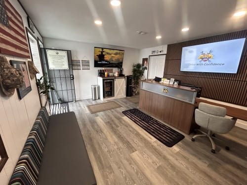 Modern office reception area at Army Mechanics Inc with seating and digital displays.