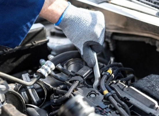 Engine repair technician inspecting vehicle engine components.