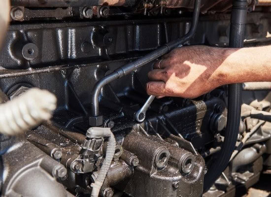 Diesel engine repair with mechanic working on engine components.