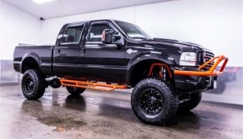 Off-road military-style truck with custom armor and accessories.