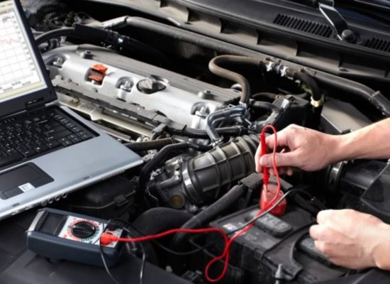 Electrical and hybrid vehicle repair technician inspecting engine components with diagnostic tools.