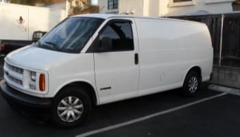 White cargo van parked in a lot, ready for repairs.