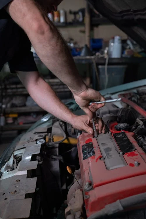 Automotive diagnostic technician inspecting engine components.