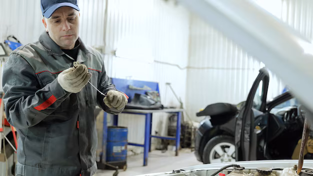a mechanic checking a cars oil meter