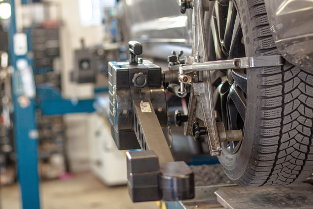Vehicle suspension repair and alignment in progress at automotive service center.