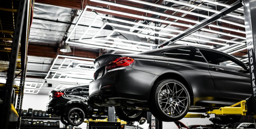 Modern automotive service shop with luxury cars on lifts, specializing in performance upgrades and r.