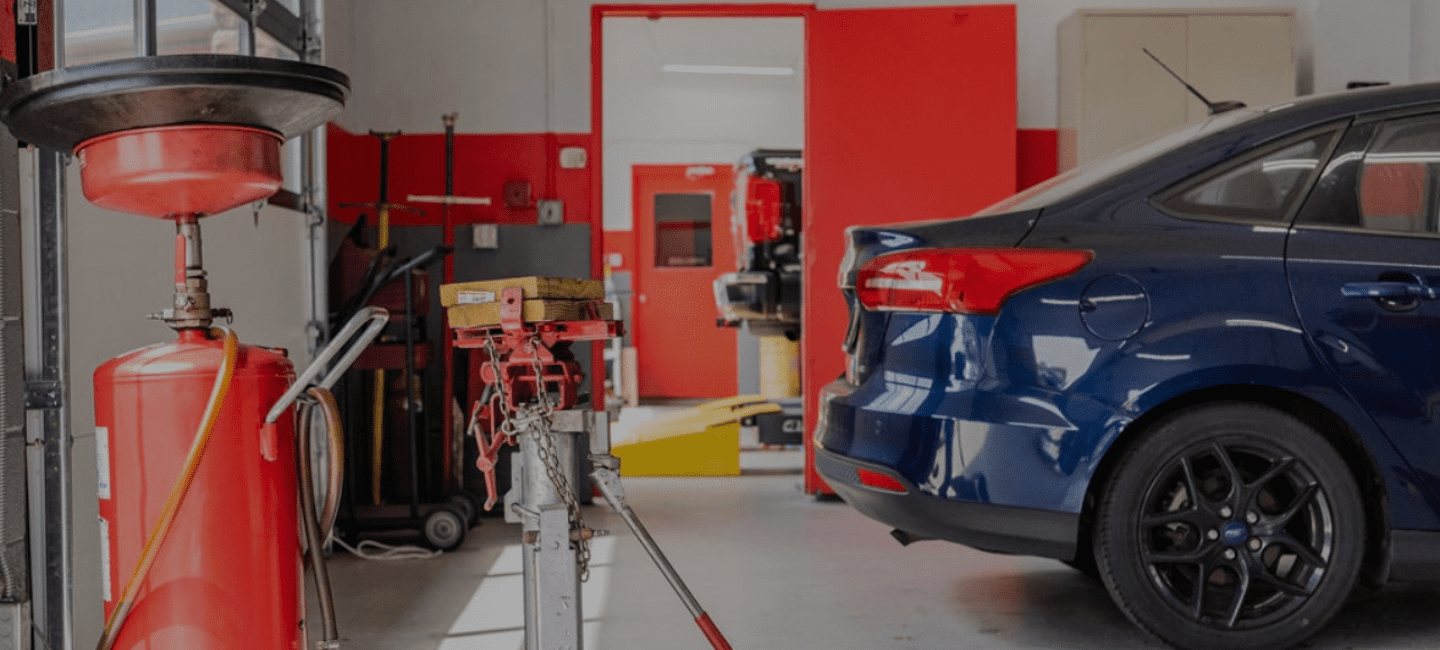 Auto repair shop with a vehicle on a lift for transmission and engine services.