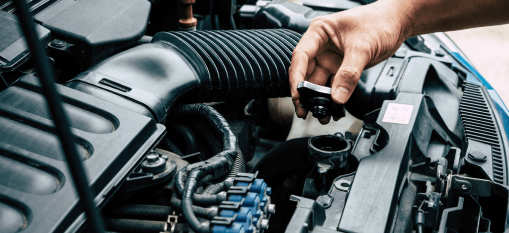 Mechanic inspecting car engine for maintenance and performance check.