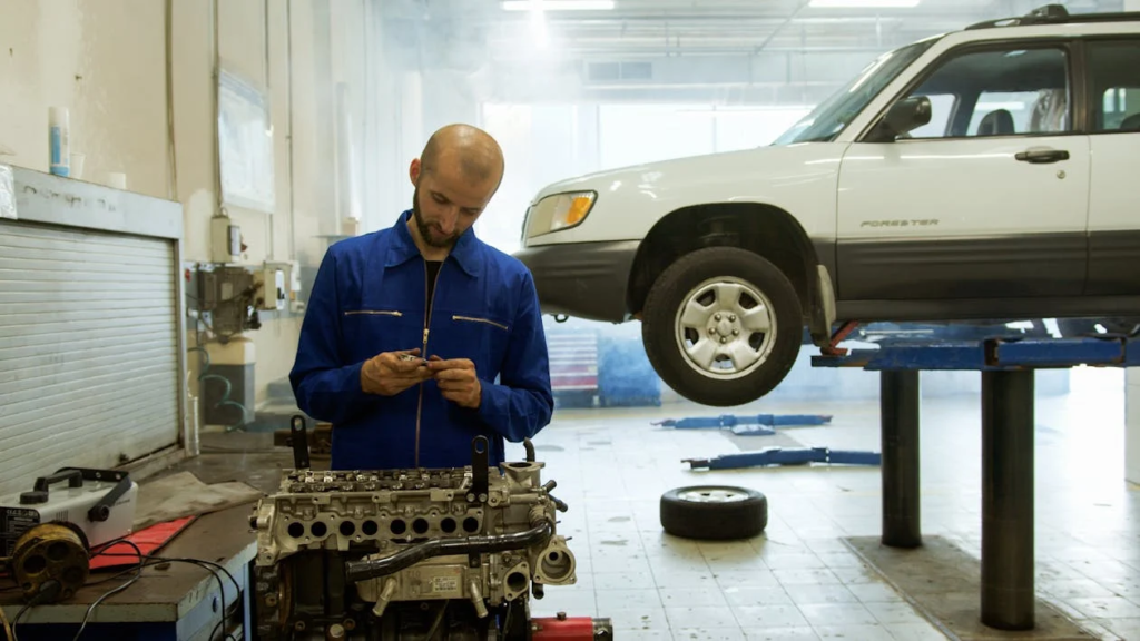 Technician performing an oil change on a vehicle in an auto repair shop.