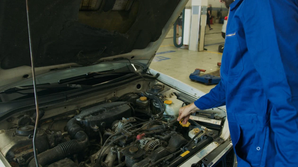Technician performing an oil change on a vehicle engine at ASAP Automotive.