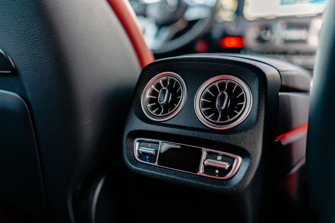 Car air conditioning vent with controls for temperature and airflow.