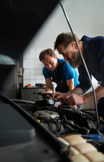 Skilled mechanics diagnosing engine issues in a modern auto repair shop.