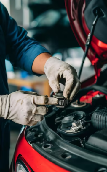 Mechanic inspecting car engine for transmission issues at ASAP Automotive & Transmission.