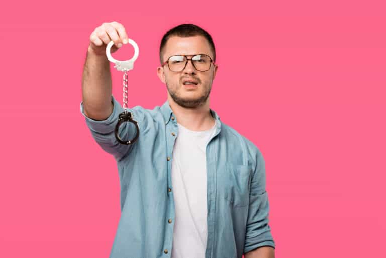 A man holding out handcuffs.