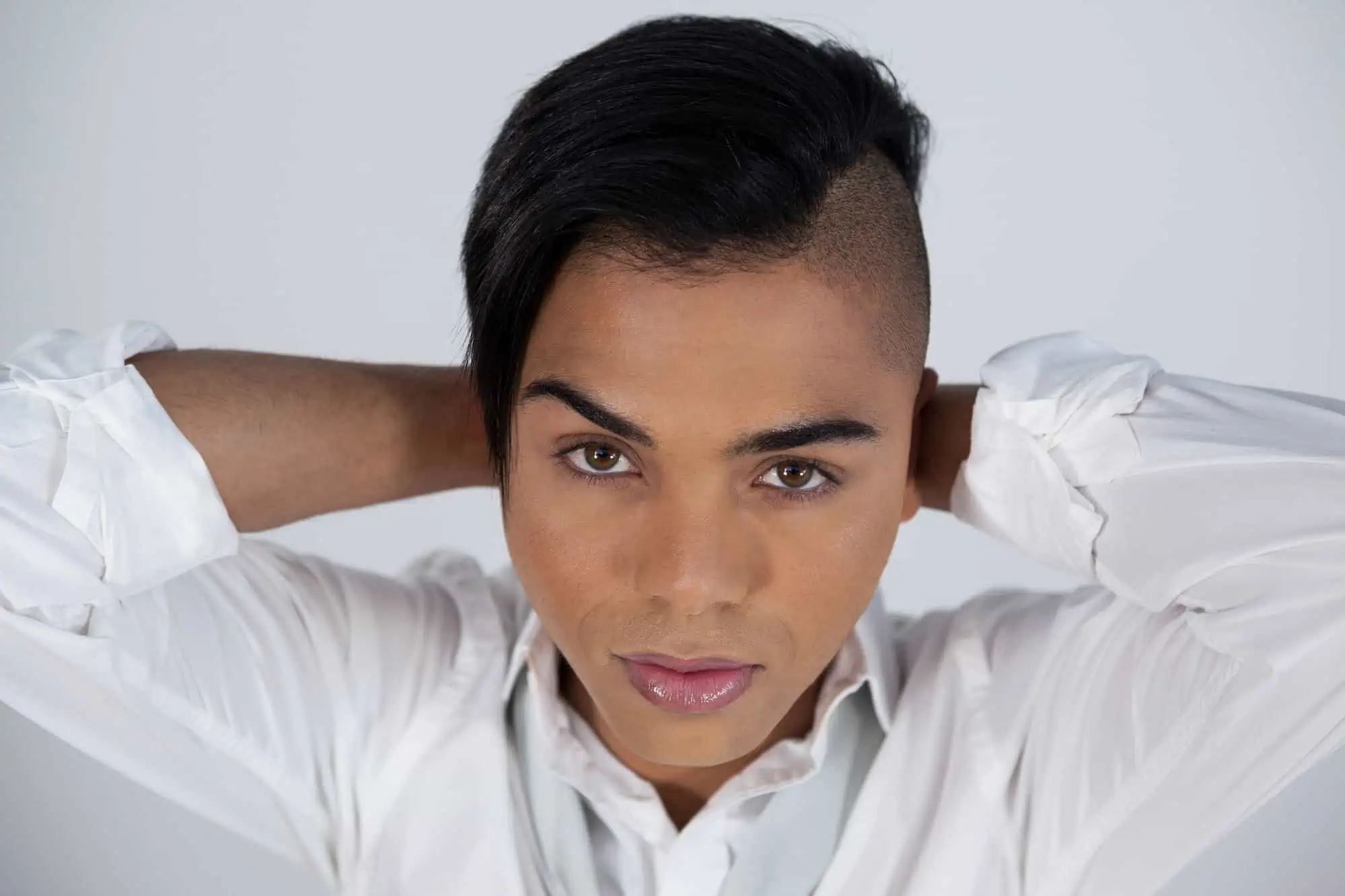 Close up portrait of transgender woman against white background