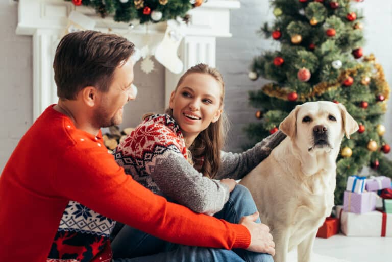 A couple of christmas morning with their dog.