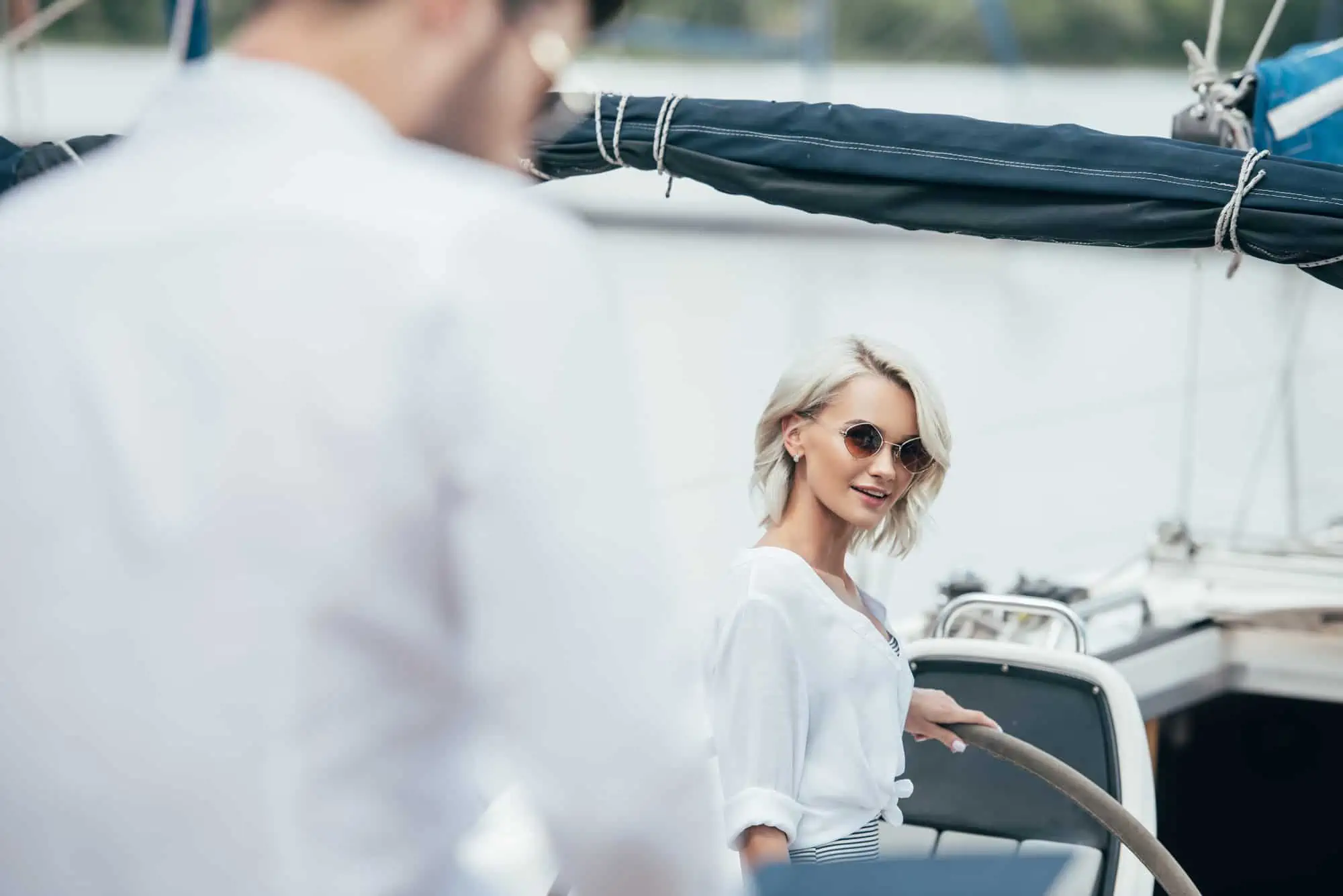 Selective focus of beautiful smiling girl in sunglasses looking at a man