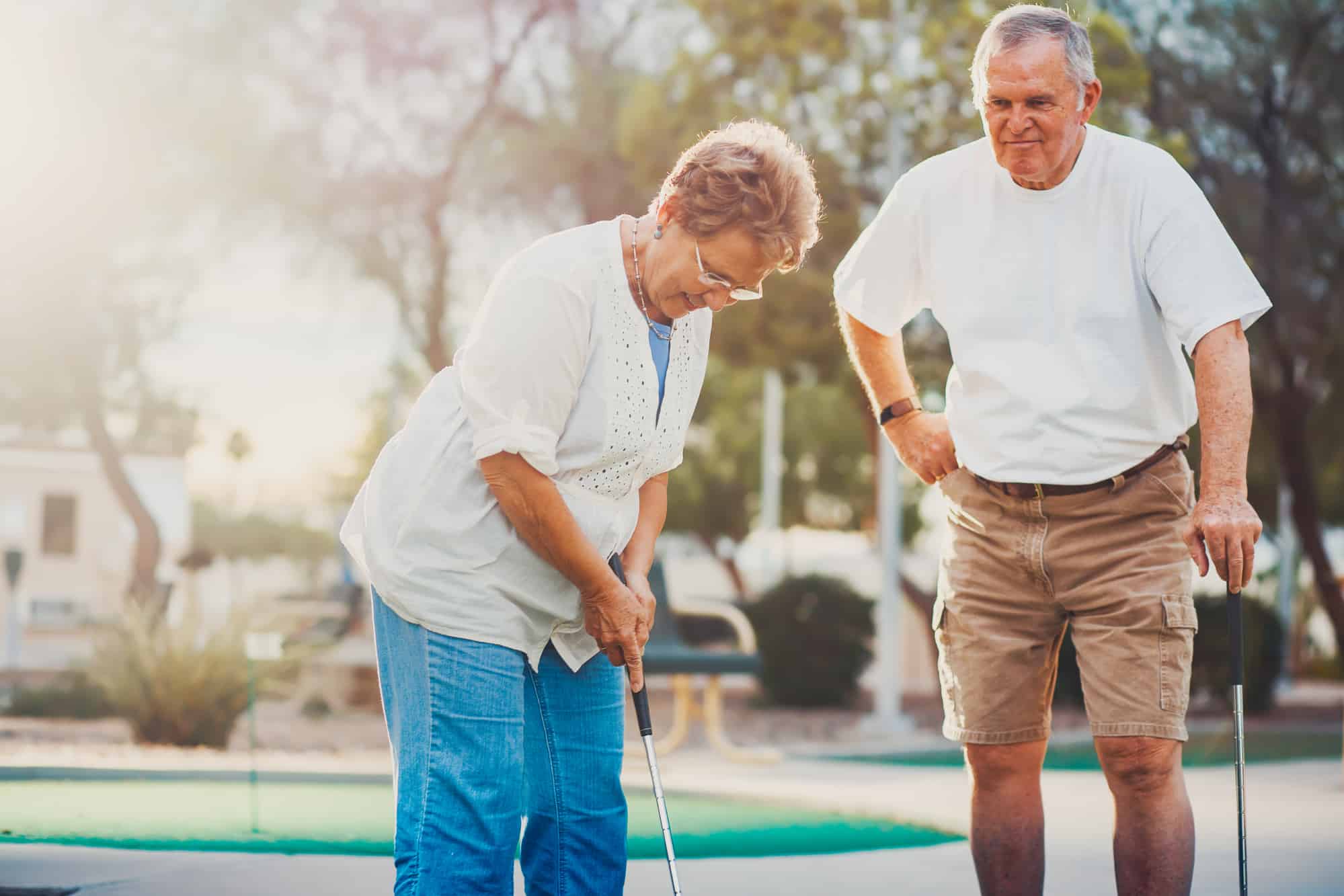 senior couple playing mini golf enjoying a retired lifestyle